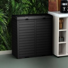 there is a black storage box next to a white shelf with a coffee maker on it