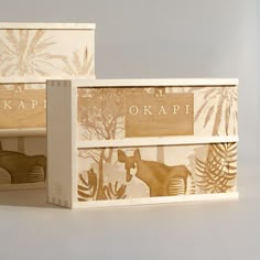 two wooden boxes with animals on them and the words okapi printed on them