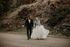 a bride and groom walking down the road