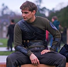 a man sitting on top of a wooden bench