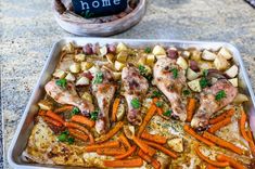 a pan filled with chicken, potatoes and carrots on top of a kitchen counter