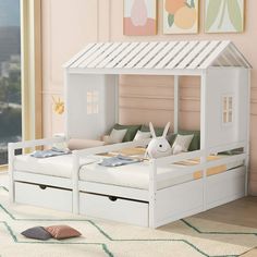 a child's bed with a white canopy over it and two drawers underneath the bed