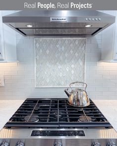 a stove top oven with a tea kettle on it's burner in a kitchen