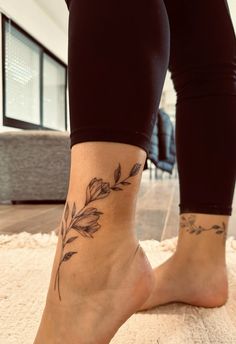 a woman's foot with a flower tattoo on her left side and the bottom part of her leg