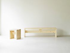 two wooden benches sitting next to each other on a white floor in front of a window