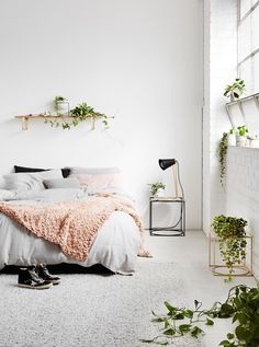 a bedroom with a cactus tapestry hanging above the bed and plants on the wall next to it