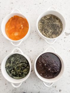 four bowls filled with different types of herbs