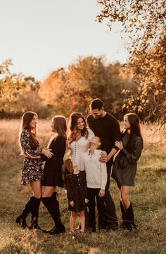 a group of people standing in a field with their arms around each other