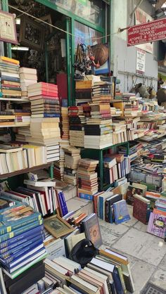 many books are stacked up on the sidewalk