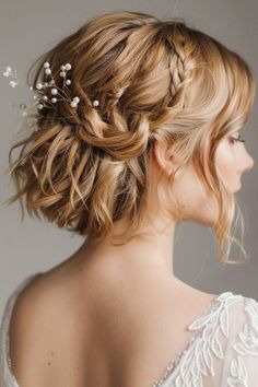 a woman with blonde hair wearing a white dress and flowers in her hair is shown from the back