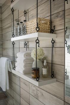 bathroom shelves with towels, soaps and other items on them in front of a mirror