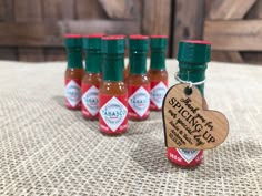 six small bottles of hot sauce sitting on top of a table