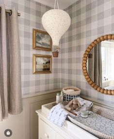 a baby's room with a crib, mirror and pictures on the wall