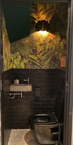 a black toilet sitting in a bathroom next to a sink