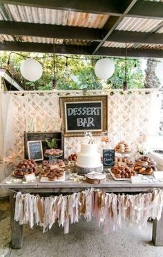 a table with desserts on it in front of a chalkboard sign that says dessert bar