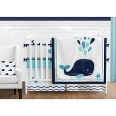 a blue and white baby bedding set with a whale theme