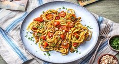 a white plate topped with pasta and tomatoes