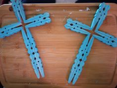 three wooden crosses sitting on top of a cutting board with holes in it's middle