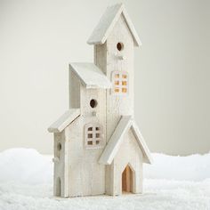 a white birdhouse sitting on top of snow covered ground