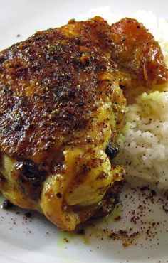 a white plate topped with meat and rice