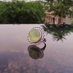 ---Prehnite Ring--- Prehnite brings comfort and peace to your heart chakra. It harmonizes the body by balancing out the masculine and feminine energies, which balances the intellectual, emotional, physical, and auric energies _._._._._._._._._._._._._._._._._._ Gemstone: Prehnite Gemstone Size: 15 mm Gemstone Shape: Round _._._._._._._._._._._._._._._._._._ Metal Type: Brass, 925 Sterling Silver Plated, Oxidized Weight :10-12 Gram (Approx) Made In: Jaipur, India _._._._._._._._._._._._._._._._._ Green Crystal Gemstone Ring For Spiritual Wear, Green Sterling Silver Spiritual Rings, Handmade Green Crystal Ring For Healing, Bohemian Green Crystal Round Ring, Spiritual Turquoise Healing Ring, Green Bohemian Crystal Ring, Spiritual Healing Turquoise Ring, Green Rings With Natural Stones For Spiritual Style, Green Crystal Healing Ring