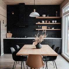 a dining room table with black chairs and wooden shelves