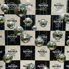 several disco balls hanging from the ceiling in front of a wall with hard rock logo