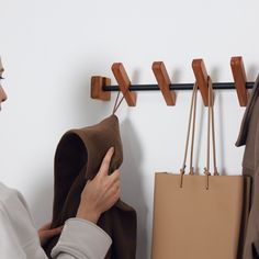 a woman looking at clothes hanging on a coat rack