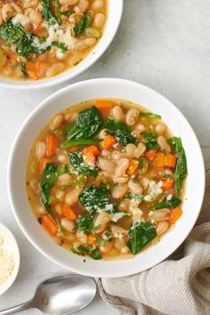 two bowls of soup with spinach and white beans