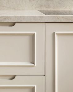 a kitchen sink and cabinet with marble counter tops