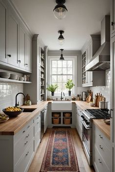 a narrow kitchen with white cabinets and wood counter tops, along with an area rug on the floor