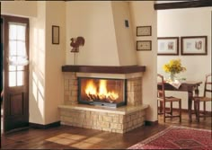 a living room with a fire place in the center and pictures on the wall above it