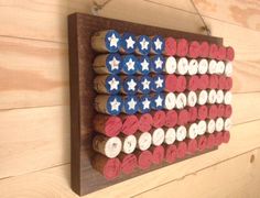 an american flag made out of wine corks hanging on a wooden paneled wall