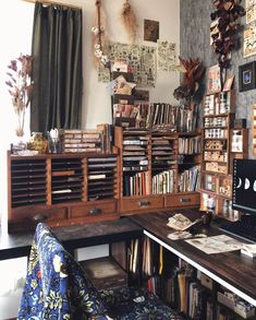 a room with bookshelves, desk and chair next to a wall covered in pictures