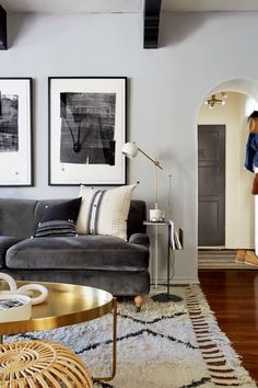 a living room filled with furniture and pictures hanging on the wall above it's doorway