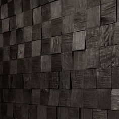 a black and white photo of a wall made out of wooden planks that are stacked on top of each other