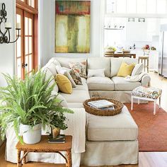 a living room filled with furniture and a large painting on the wall above it's windows