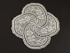 a white doily is shown on a black surface