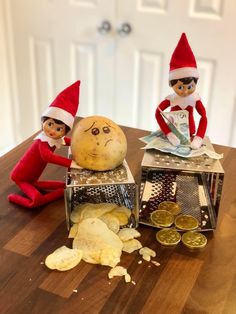 two elfs sitting on top of a wooden table next to some food and money