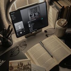 an open book sitting on top of a desk next to a computer monitor