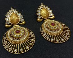 Elevate your style with our gold-plated earrings, featuring kundan and gray stones in a statement designer piece. Intricate gold carvings add a touch of elegance and sophistication, making these earrings perfect for any special occasion. Earrings Dimensions: Approximately 3.2 Inches Long  Approximately 2 Inches Wide  A Earring weight is 0.76 oz All our products are crafted using traditional skills from our rich heritage. The manual nature of these crafts means that irregularities or variations a Bollywood Style Chandbali Filigree Earrings, Bollywood Style Filigree Earrings For Festive Occasions, Bollywood Style Yellow Gold Cutdana Earrings, Heavy Chandbali Earrings In Brass, Heavy Chandbali Brass Earrings, Traditional Gold Cutdana Earrings, Heavy Gold Chandbalis For Festivals, Gold Bollywood Ceremonial Earrings, Traditional Gold Plated Filigree Danglers