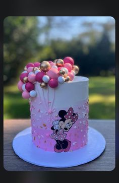 a minnie mouse cake with pink and gold decorations