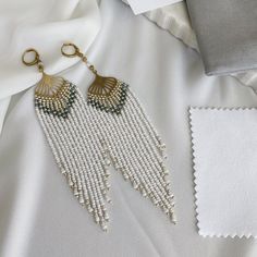 White beaded earrings, long seed bead earrings, bohemian jewelry, raw brass, these long fringe boho earrings are available in raw brass. Stunning complimentary colored round White and Gold Czech beads handwoven large raw brass lever back earrings, light weight.  *  Strong quality bead weaving thread *  Lever Back ear wire - raw brass *  Approx total length from top to bottom including ear wire hoops are approx. 13 cm long by 3 cm wide *  Quality Czech seed beads ♡ UNLOCK THE PERFECT GIFT-GIVING White Beaded Earrings, Seed Bead Fringe Earrings, Bead Fringe Earrings, Bead Fringe, Earrings Bohemian, Beaded Fringe, Earrings Long, Modern Bohemian, Seed Bead Earrings