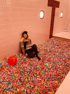 a woman sitting on the floor in a bath room filled with sprinkles