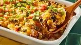 a casserole dish with vegetables and meat in it on a green counter top