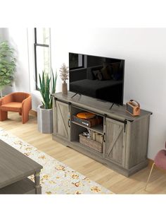 a flat screen tv sitting on top of a wooden entertainment center in a living room