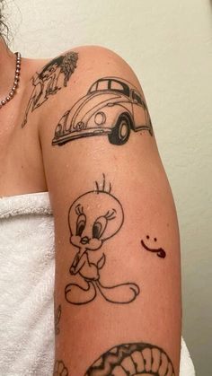 a woman's arm with tattoos on it and an image of a cartoon character