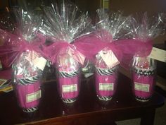 three pink vases wrapped in plastic and tied with ribbon