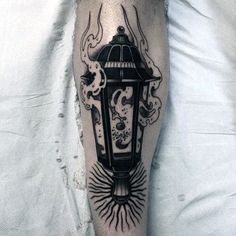 a man's leg with a lantern tattoo on it