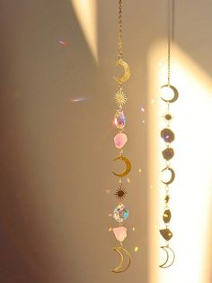 the sun shines brightly through the window and reflects on the moon, stars, and crescentes hanging from chains